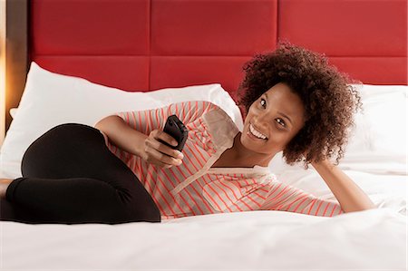 simsearch:614-06719671,k - Woman using cell phone on bed Fotografie stock - Premium Royalty-Free, Codice: 614-06719666