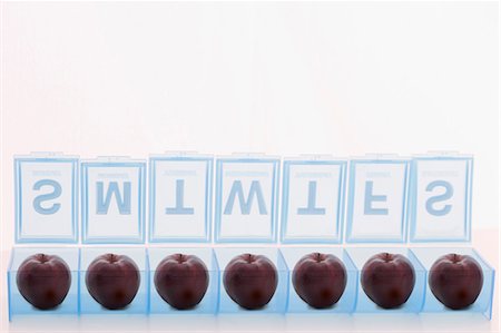 Pill holder containing apples Stock Photo - Premium Royalty-Free, Code: 614-06719737