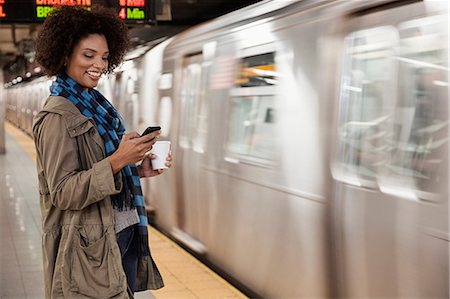 Woman using cell phone at subway station Stock Photo - Premium Royalty-Free, Code: 614-06719731