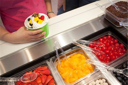 frozen yogurt - Girl putting toppings on frozen yogurt Stock Photo - Premium Royalty-Free, Code: 614-06719836
