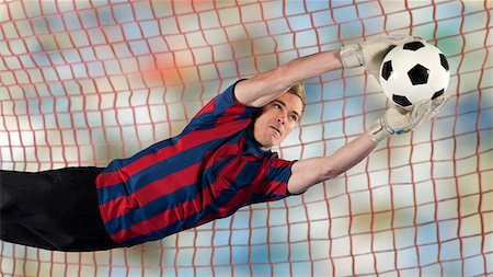 Soccer player catching ball in air Stock Photo - Premium Royalty-Free, Code: 614-06719868