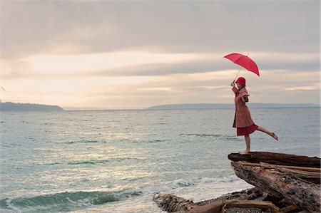 edge of lake - Woman with umbrella on coastal cliff Stock Photo - Premium Royalty-Free, Code: 614-06719878