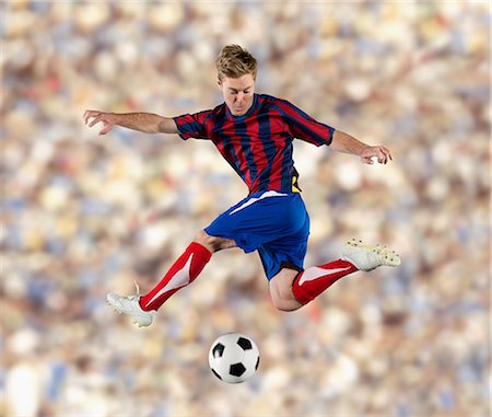 soccer jump - Soccer player kicking ball in air Stock Photo - Premium Royalty-Free, Code: 614-06719873
