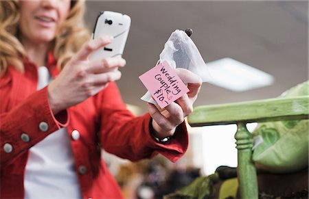 phone and shopping - Woman taking picture in thrift store Stock Photo - Premium Royalty-Free, Code: 614-06719954