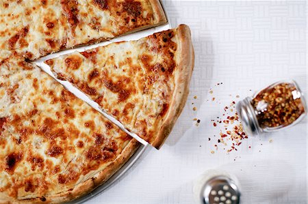 pizza from above on white - Pizza slice with spilled chili flakes Stock Photo - Premium Royalty-Free, Code: 614-06720035