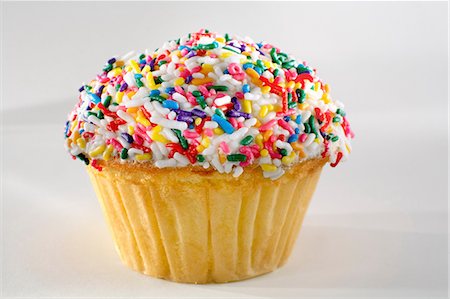 simsearch:614-03191356,k - Close up of rainbow sprinkles cupcake Stock Photo - Premium Royalty-Free, Code: 614-06720046