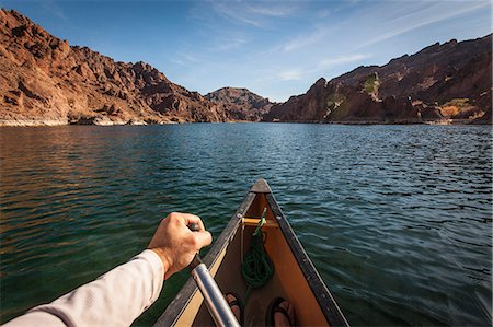 Man rowing canoe on still rural lake Stock Photo - Premium Royalty-Free, Code: 614-06720064