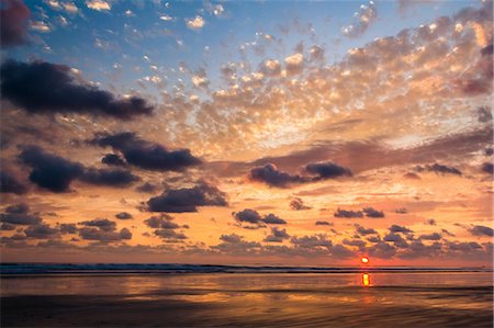 Sun setting over water in dramatic sky Foto de stock - Sin royalties Premium, Código: 614-06720077