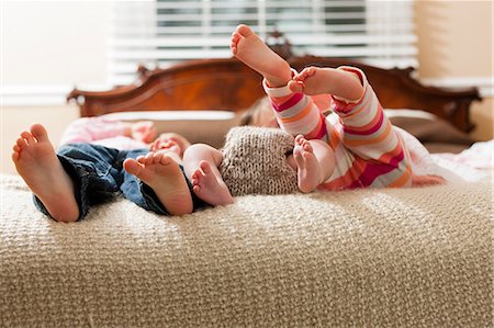 siblings lying - Children laying with infant on bed Stock Photo - Premium Royalty-Free, Code: 614-06720135