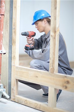 Female laborer using electric drill on construction site Stock Photo - Premium Royalty-Free, Code: 614-06814007