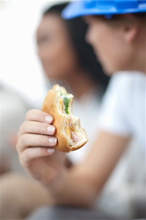 diverse people eating not illustration not monochrome and people - Female worker holding sandwich Stock Photo - Premium Royalty-Free, Code: 614-06814014