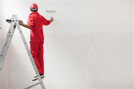 Decorator on step ladder painting white wall Foto de stock - Sin royalties Premium, Código: 614-06814024