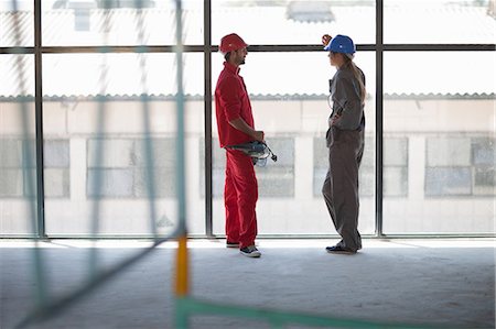 face to face communication in construction site - Laborers talking in front of window Stock Photo - Premium Royalty-Free, Code: 614-06814025