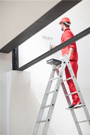 Decorator on ladder painting interior wall Photographie de stock - Premium Libres de Droits, Code: 614-06814022