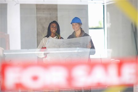Architect and construction worker discussing blueprint on construction site Stock Photo - Premium Royalty-Free, Code: 614-06814037