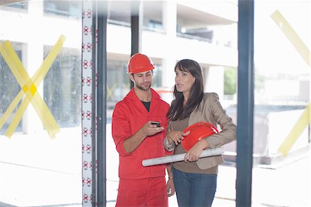 females working in hard hats - Architect and building contractor with smartphone Stock Photo - Premium Royalty-Free, Code: 614-06814030