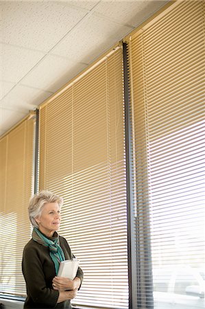 Senior woman looking through window Stock Photo - Premium Royalty-Free, Code: 614-06814086