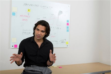 explicando - Young man with whiteboard in background Foto de stock - Sin royalties Premium, Código: 614-06814119