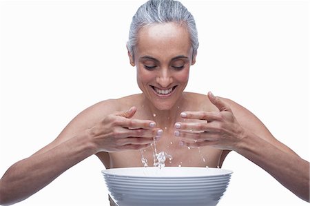 senior woman white background - Mature woman washing face Stock Photo - Premium Royalty-Free, Code: 614-06814181