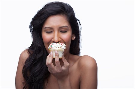 simsearch:614-06814211,k - Young woman eating cupcake Photographie de stock - Premium Libres de Droits, Code: 614-06814196