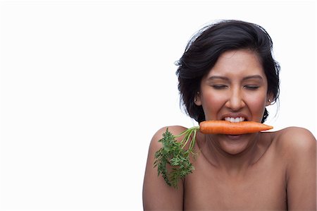 simsearch:614-06814232,k - Young woman biting carrot Fotografie stock - Premium Royalty-Free, Codice: 614-06814197