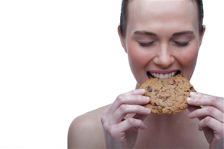 simsearch:614-06814251,k - Young woman biting cookie Foto de stock - Sin royalties Premium, Código: 614-06814229