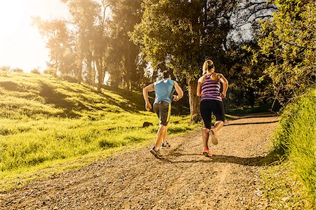 sunlight forest - Two people jogging on forest path Photographie de stock - Premium Libres de Droits, Code: 614-06813179