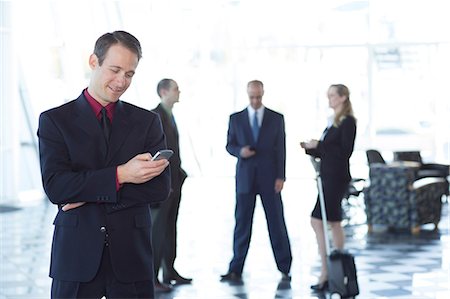 people in lobby - Businessman using cell phone Stock Photo - Premium Royalty-Free, Code: 614-06813213