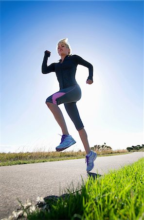 Young woman jogging, low angle Stock Photo - Premium Royalty-Free, Code: 614-06813538