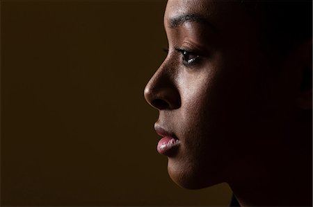 sad alone profile - Side view of young woman on black background Stock Photo - Premium Royalty-Free, Code: 614-06813604