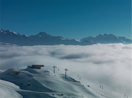 swiss alps winter - Ski lifts in ski resort with low cloud Stock Photo - Premium Royalty-Free, Code: 614-06813697