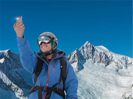 Young man photographing self on smartphone in mountains Foto de stock - Sin royalties Premium, Código: 614-06813699