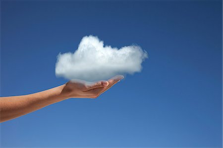 security - Hand holding cloud against blue sky Stock Photo - Premium Royalty-Free, Code: 614-06813705