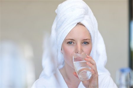 Young woman wearing towel on head drinking water Stock Photo - Premium Royalty-Free, Code: 614-06813803
