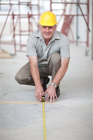 people constructing buildings - Builder measuring floor space on construction site Stock Photo - Premium Royalty-Free, Code: 614-06813855