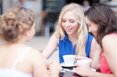 Young women chatting with friends at cafe Foto de stock - Sin royalties Premium, Código: 614-06813897