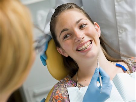 dentist gloves - Young woman smiling in dentist's chair Stock Photo - Premium Royalty-Free, Code: 614-06895758