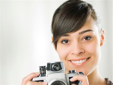 Young woman holding camera, portrait Photographie de stock - Premium Libres de Droits, Code: 614-06895811