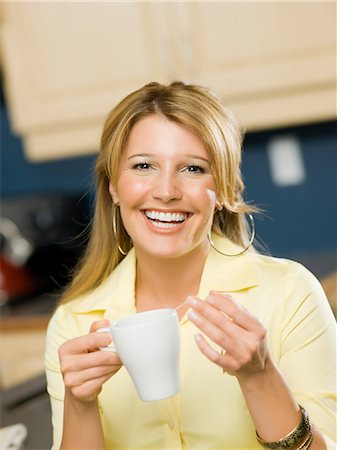 people in yellow - Mid adult woman holding cup and smiling, portrait Stock Photo - Premium Royalty-Free, Code: 614-06895823