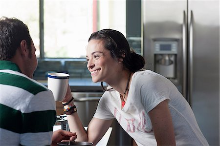 Young couple enjoying coffee in kitchen, smiling Foto de stock - Sin royalties Premium, Código: 614-06895881