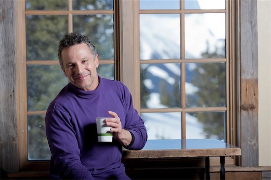 Mature man holding hot drink indoors, smiling Stock Photo - Premium Royalty-Free, Image code: 614-06896037