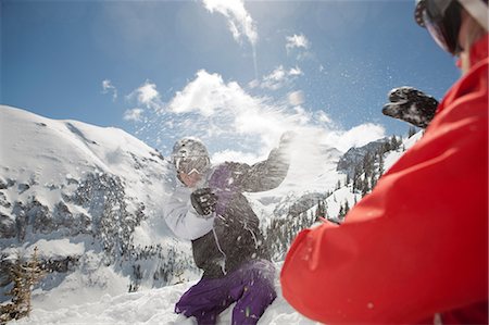 sport and ski - Mid adult man and young woman in skiwear having snowball fight Stock Photo - Premium Royalty-Free, Code: 614-06896052