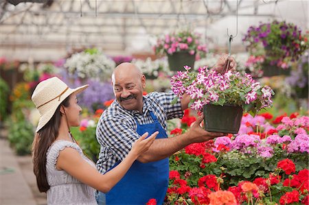 Mature man serving young woman in garden centre, smiling Photographie de stock - Premium Libres de Droits, Code: 614-06896182