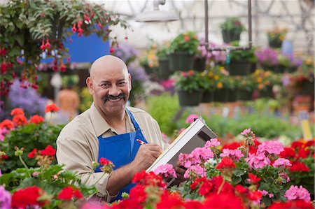 pictures of man in 50s in garden - Mature man using clipboard in garden centre, portrait Stock Photo - Premium Royalty-Free, Code: 614-06896198
