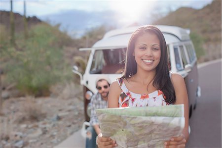Young woman holding map on road trip, smiling Fotografie stock - Premium Royalty-Free, Codice: 614-06896209