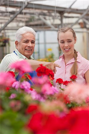 simsearch:614-06896327,k - Senior gardener serving mid adult woman in garden centre, smiling Foto de stock - Sin royalties Premium, Código: 614-06896210