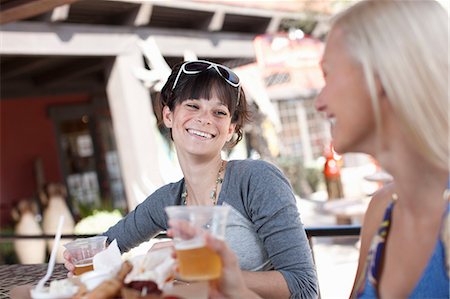 people snacking - Girlfriends having drinks in outdoor cafe, smiling Stock Photo - Premium Royalty-Free, Code: 614-06896236