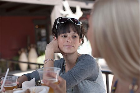 friendship day with beer - Girlfriends having drinks in outdoor cafe, smiling Stock Photo - Premium Royalty-Free, Code: 614-06896237