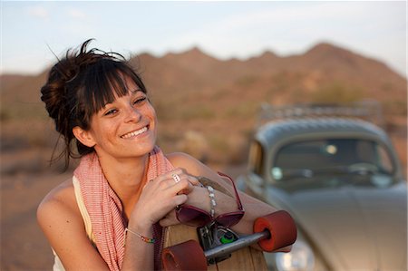 Young woman leaning on skateboard outdoors, portrait Stock Photo - Premium Royalty-Free, Code: 614-06896260