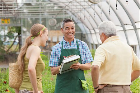 Mature sales assistant serving senior man and mid adult woman in garden centre Stock Photo - Premium Royalty-Free, Code: 614-06896279